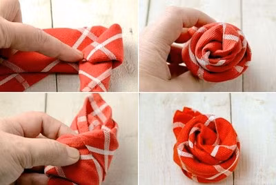 Gấp mép vải đầu bên phải vào trong, sao cho đầu mép vải nằm cùng phía với góc vuông ở giữa. Sau đó, bạn cuộn tròn dải vải vừa gấp theo hướng từ phải sang trái, phần vải gấp đầu dải vải làm nhụy hoa. Sau khi cuộn xong, phần đầu vừa thừa bên trái dùng tay ấn nhồi vào trong nếp gấp cuộn tròn tạo hình bông hoa hồng.