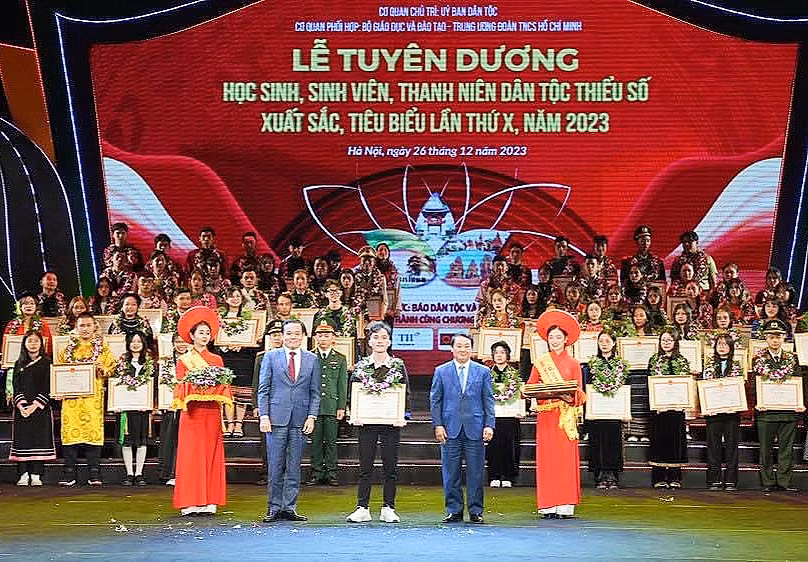 Ông Hầu A Lềnh - Bộ trưởng, Chủ nhiệm Uỷ ban Dân tộc (bên phải) tặng Bằng khen cho em Sùng A Chua trong lễ tuyên dương học sinh, sinh viên, thanh niên dân tộc thiểu số xuất sắc, tiêu biểu lần thứ X, năm 2023.