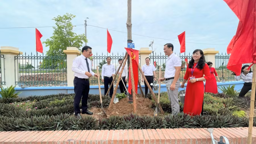 Các đại biểu thực hiện nghi thức trồng cây lưu niệm trong khuôn viên Trường Mầm non Cổ Đô.