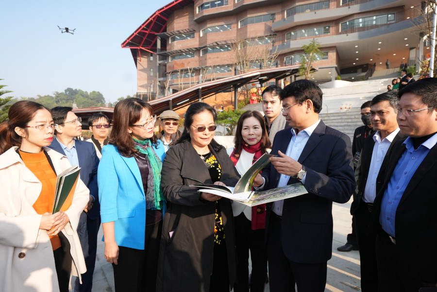 Bà Nguyễn Thị Kiều Oanh, Tổng giám đốc Tập đoàn đầu tư Khôi Nguyên (áo đen) giới thiệu khuôn viên trường cho các đại biểu.