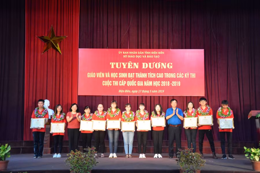 Bà Giàng Thị Hoa, PCT HĐND tỉnh Điện Biên (thứ 3 bên trái) và ông Nguyễn Văn Kiên (áo xanh) trao thưởng cho học sinh