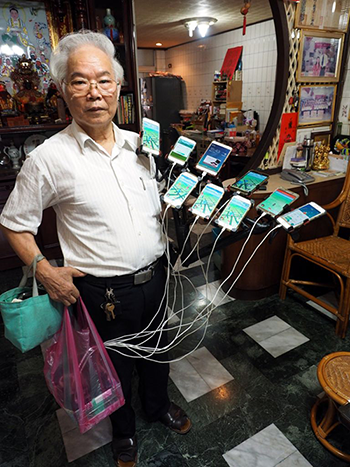 Ông Chen và các thiết bị công nghệ dùng để bắt Pokemon. Ông Chen và các thiết bị công nghệ dùng để bắt Pokemon. Ảnh: EPA