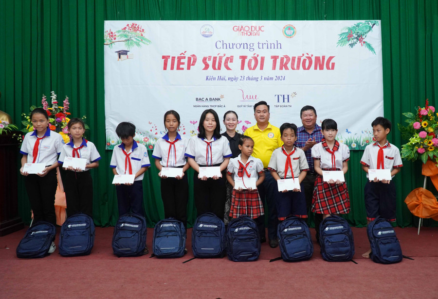 Ông Nguyễn Thanh Sơn - Giám đốc Công ty Sách thiết bị trường học TP Cần Thơ và bà Trần Thị Yến Oanh, Phó Chủ tịch UBND xã An Sơn trao học bổng và quà. Ảnh: Mạnh Tùng.