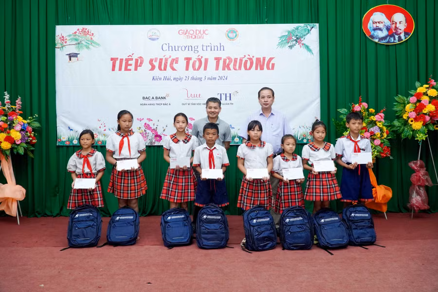 Nhà báo Nguyễn Đức Tuân, Phó Tổng biên tập Báo Giáo dục và Thời đại (trái) và Phó Chủ tịch UBND huyện Kiên Hải trao học bổng và quà cho học sinh. Ảnh: Mạnh Tùng.