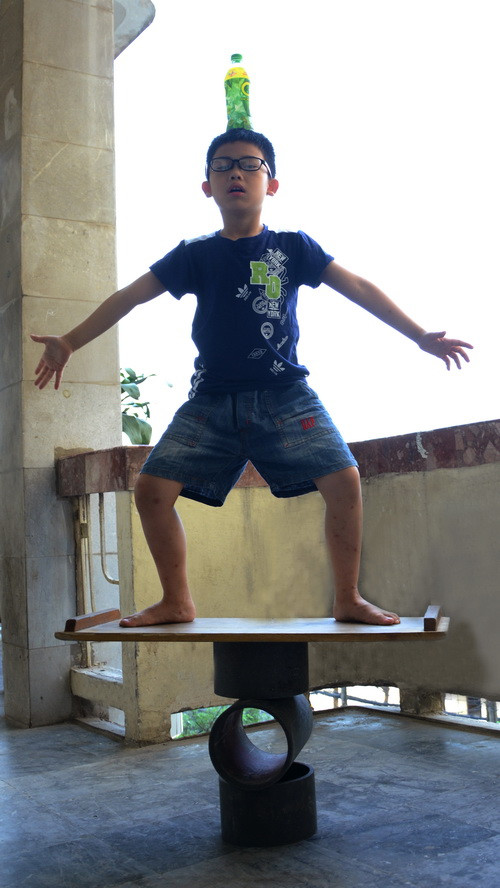 Nguyễn Đình Khánh Hưng với tiết mục đội chai lên đầu, đứng trên 3 con lăn Nguyễn Đình Khánh Hưng với tiết mục đội chai lên đầu, đứng trên 3 con lăn