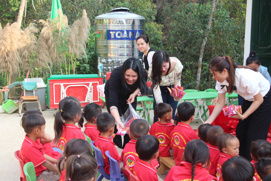 Chị Hoàng Thị Hoa (áo đen) phát quà cho trẻ tại điểm bản Pú Chả. Chị Hoàng Thị Hoa (áo đen) phát quà cho trẻ tại điểm bản Pú Chả.