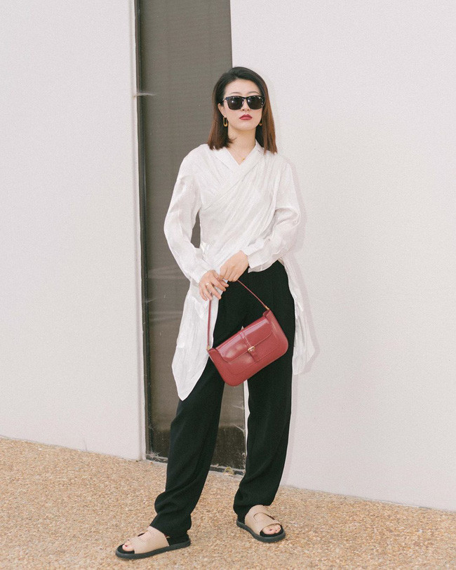 Bằng cách mix quần đen ống suông rộng với áo blouse trắng, bạn sẽ có được vẻ ngoài cực kỳ thanh lịch mà chẳng kém phần thời thượng, phóng khoáng. Đừng quên là khi diện đồ trung tính, bạn có thể thoải mái hơn khi mix phụ kiện màu mè nên hãy mạnh dạn chọn một chiếc túi đỏ sắc nét để tạo điểm nhấn nhé.