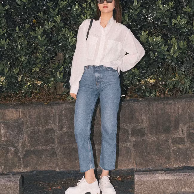 Bạn có thể kết lại bộ đôi áo sơ mi trắng tinh tươm + quần jeans ống đứng bằng một đôi sneaker trắng, vẻ ngoài trông sẽ rất trẻ trung, sành điệu nhưng điểm thanh lịch không hề sụt giảm chút nào.