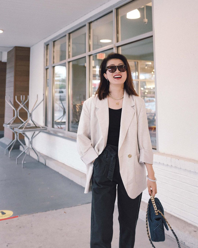 Combo áo thun + quần jeans xuyệt tông đen mix với blazer trắng kem là công thức chị em nên ghim ngay để &quot;quẩy&quot; khi trời chuyển dịu mát. Sự xuất hiện của chiếc blazer sáng màu đã thắp sáng cả set trang phục, giúp vẻ ngoài của người diện thêm trẻ trung nhưng vẫn đủ tinh tế, nhã nhặn.