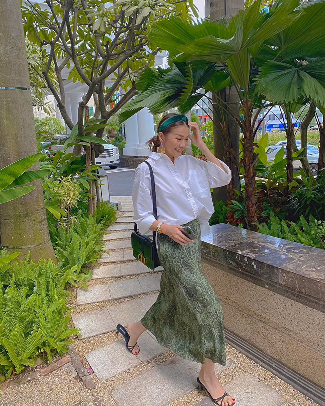 Mix áo sơ mi trắng với chân váy dáng suông là cách nhanh nhất để có được vẻ ngoài thanh lịch, trang nhã. Và trong trường hợp của Thanh Hằng, cô còn khiến tổng thể thêm phần ấn tượng khi chọn chân váy họa tiết động vật, và không quên nhấn nhá hợp lý các món phụ kiện như bờm tóc, khuyên tai, đồng hồ.