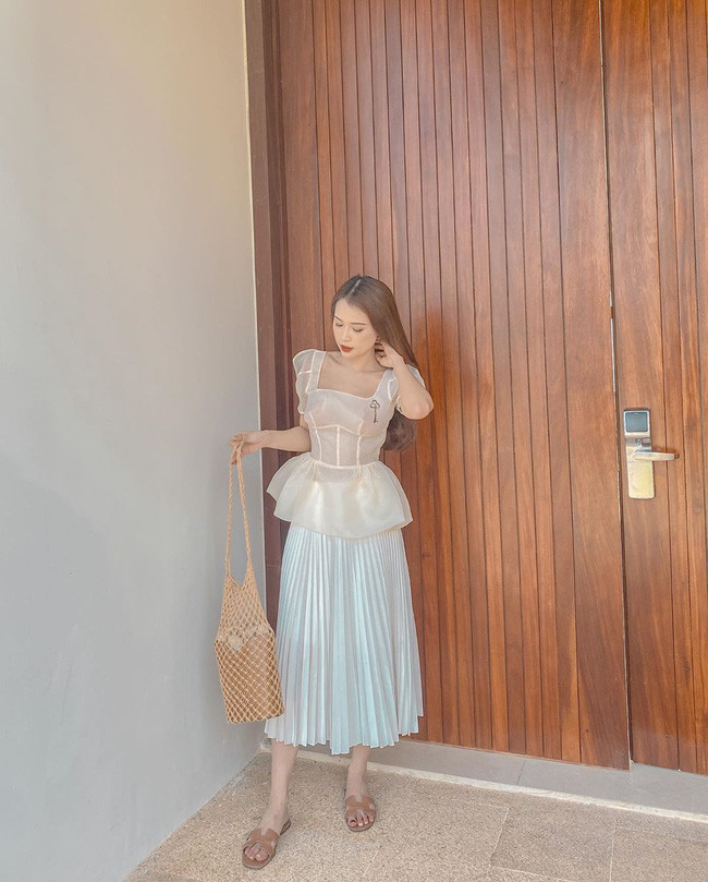 Lên đồ với toàn những items trendy như áo tay bồng + chân váy xếp li, và còn ưu ái gam màu trắng, Sam dễ dàng có được set trang phục nữ tính, xinh tươi mà chẳng kém phần sang xịn.