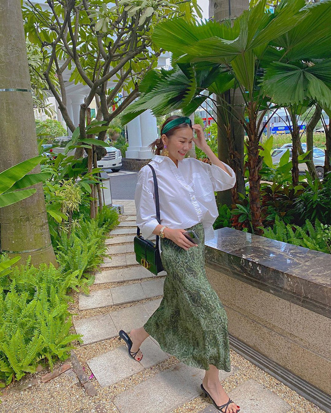 Mix áo sơ mi trắng với chân váy dáng suông là cách nhanh nhất để có được vẻ ngoài thanh lịch, trang nhã. Và trong trường hợp của Thanh Hằng, cô còn khiến tổng thể thêm phần ấn tượng khi chọn chân váy họa tiết động vật, và không quên nhấn nhá hợp lý các món phụ kiện như bờm tóc, khuyên tai, đồng hồ.
