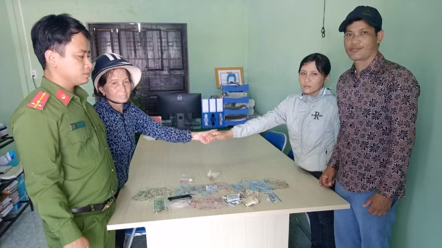 Vợ chồng anh Lộc Anh và chị Huyền trao trả lại toàn bộ tài sản nhặt được cho người đánh rơi dưới sự chứng kiến của công an xã. Ảnh: CQCA