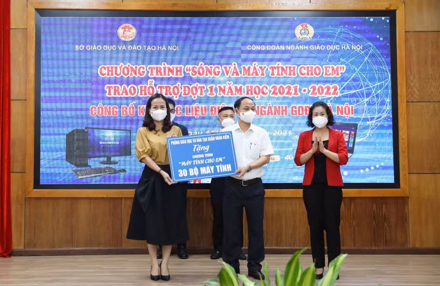 Đồng chí Vương Hương Giang - Quận ủy viên, Trưởng phòng Giáo dục và Đào tạo quận Hoàn Kiếm (bìa trái) thay mặt ngành GD Quận tặng 30 bộ máy tính cho học sinh có hoàn cảnh khó khăn trên địa bàn thành phố Hà Nội