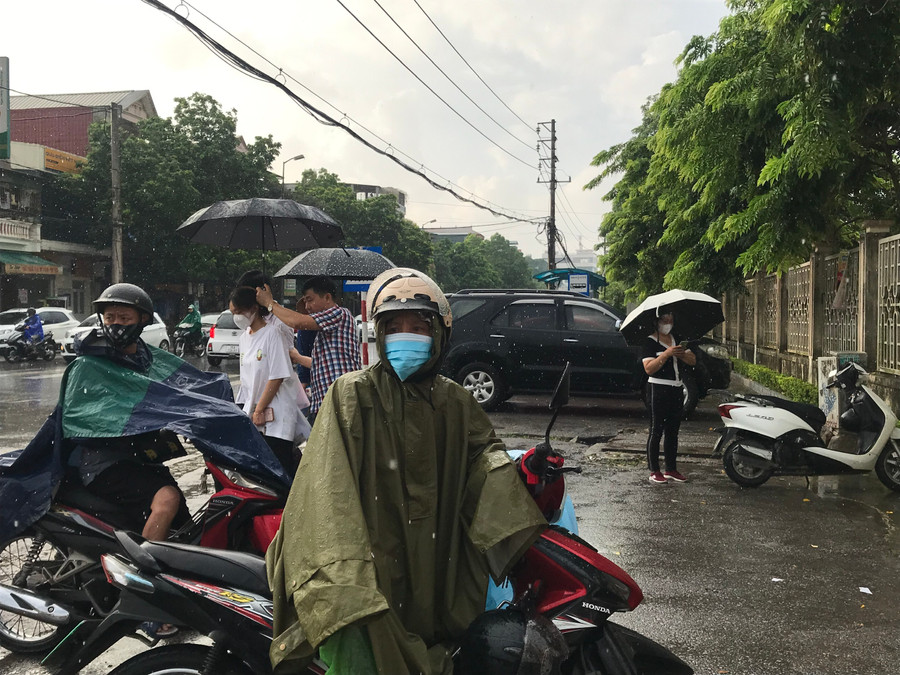 Phụ huynh &quot;đội mưa&quot; lo lắng cho sĩ tử tại điểm thi Trường THPT chuyên Lam Sơn. Ảnh: Lường Toán.