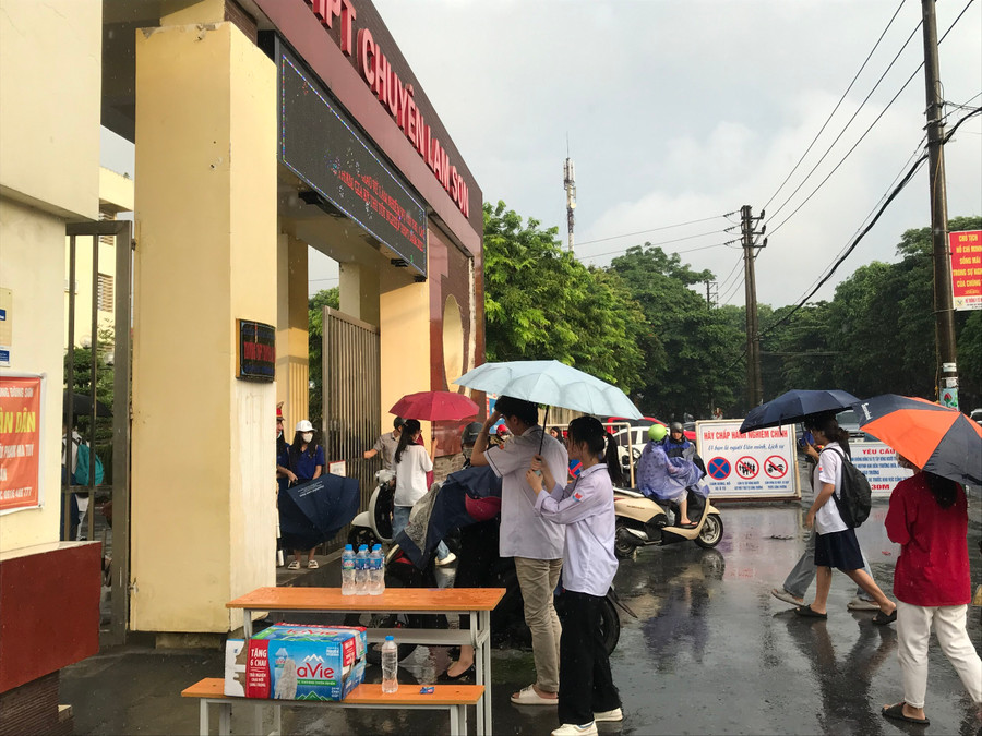 Thí sinh &quot;đội mưa&quot; đến điểm thi Trường THPT chuyên Lam Sơn. Ảnh: Lường Toán.