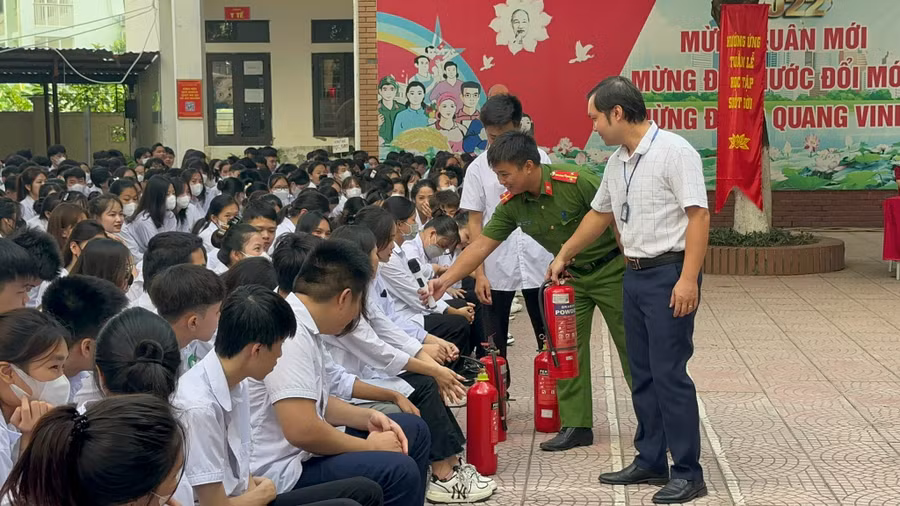 Học sinh đặt câu hỏi với các báo cáo viên về kỹ năng phòng cháy tại sân trường.