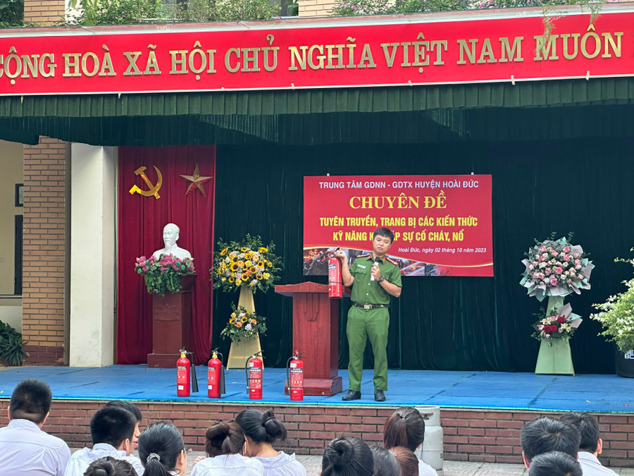 Các em học sinh tại Trung tâm GDNN-GDTX huyện Hoài Đức lắng nghe báo cáo viên phân tích cách sử dụng bình cứu hỏa.