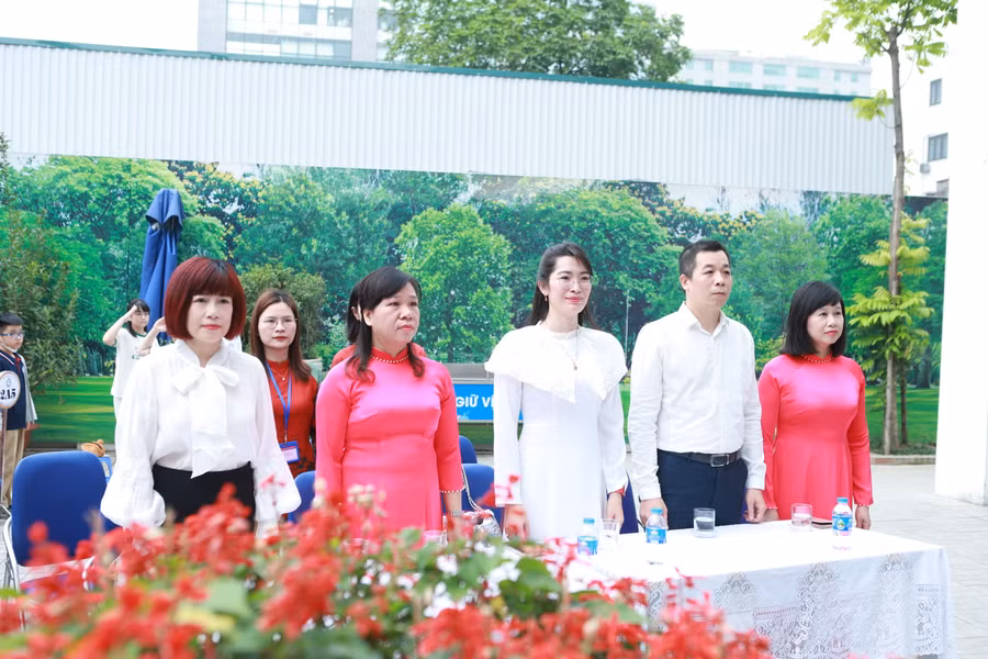 Các đại biểu tham dự đứng lên làm lễ chào cờ đầu tuần.