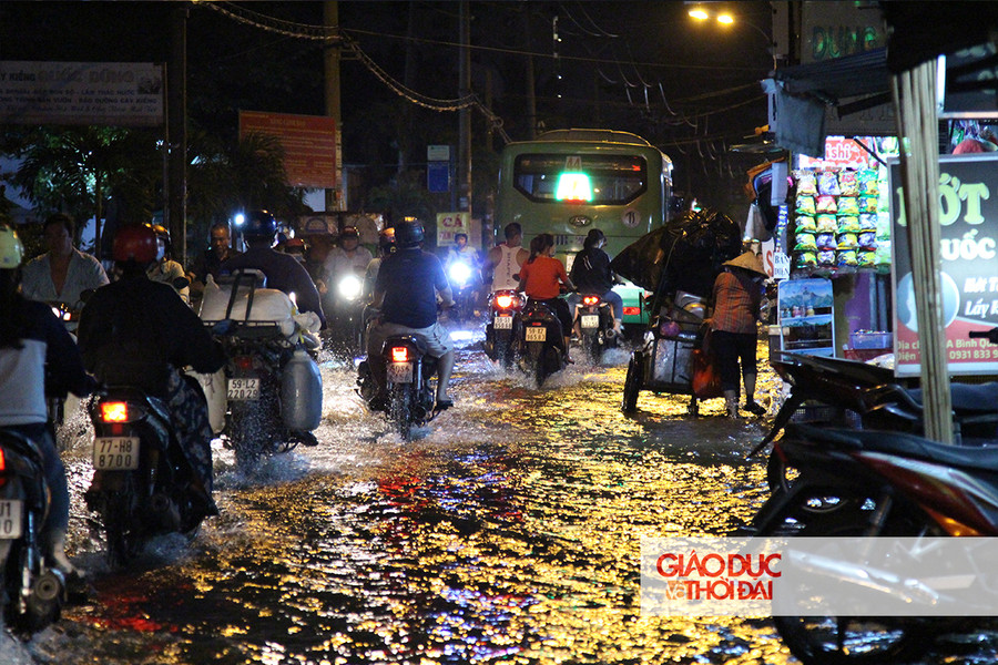 Do điểm ngập sâu nằm ở ven hai bên vỉa hè, nhiều người đã chọn cách nối đuôi nhau thành hàng dài, di chuyển ở trung tâm đoạn đường.