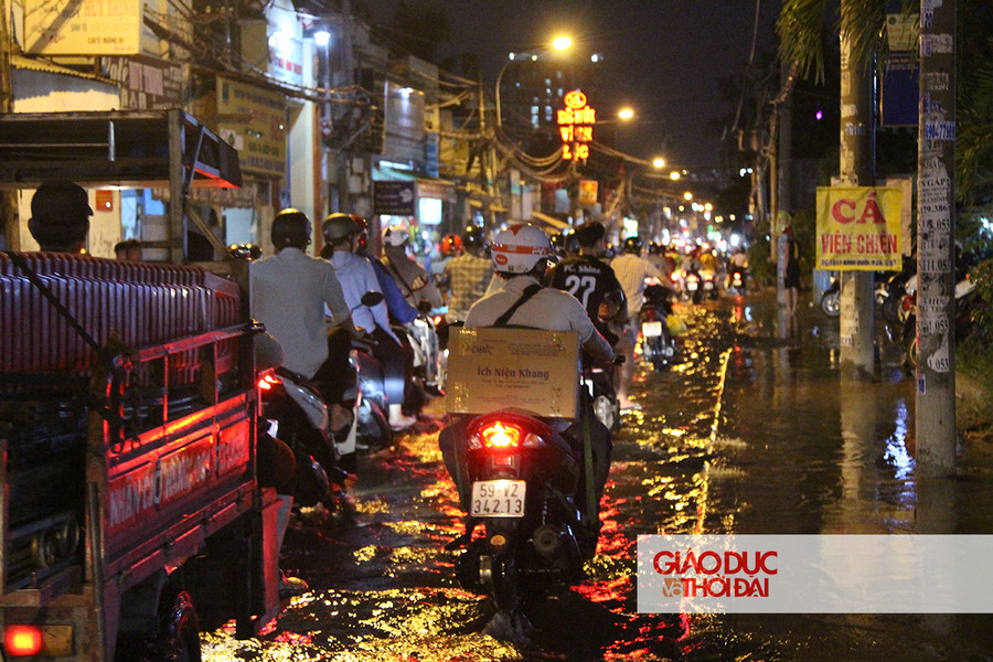 Dù nước ngập khắp một đoạn đường dài, người dân vẫn phải di chuyển vì đây là con đường duy nhất dẫn ra các Quận khác.