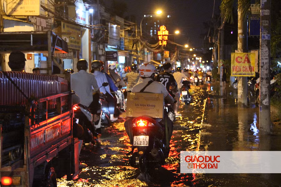 Dù nước ngập khắp một đoạn đường dài, người dân vẫn phải di chuyển vì đây là con đường duy nhất dẫn ra các Quận khác.