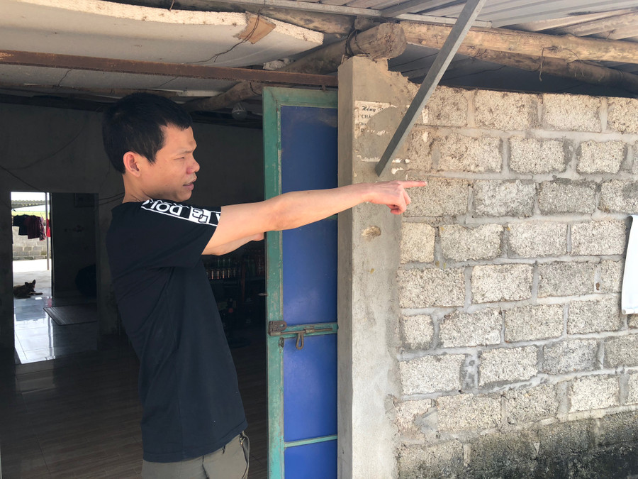 Anh Khoa đứng trước căn nhà đang ở chỉ tay về phía hồ Núi Cốc, lo lắng mùa nước năm nay sẽ tiếp tục bị ngập trong nước