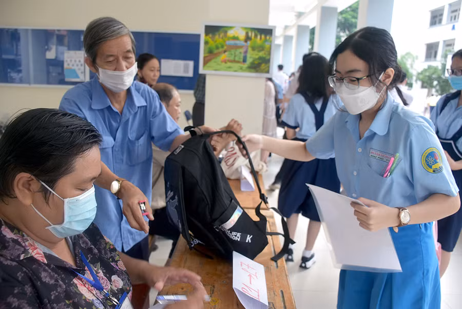 Thí sinh tại điểm thi Trường THPT Bùi Thị Xuân gửi vật dụng cá nhân trước khi vào phòng thi.