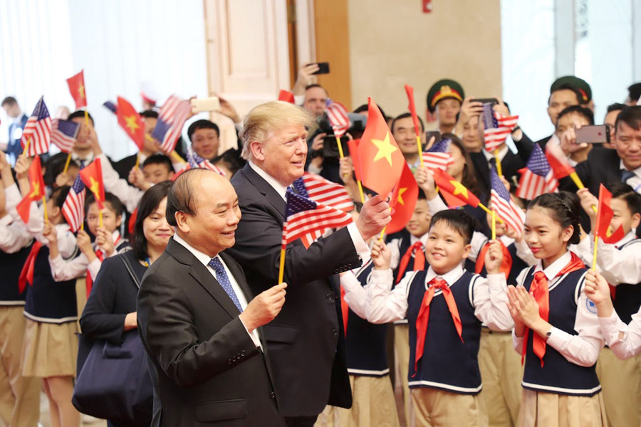 Tổng thống Donald Trump cầm lá cờ Việt Nam trước các học sinh Hà Nội khi có cuộc hội kiến với Thủ tướng Nguyễn Xuân Phúc. Ảnh: Quang Khánh