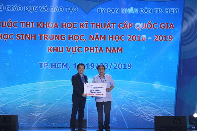 TS. Vũ Tường Thụy – Phó Hiệu trưởng Trường Đại học Hoa Sen trao học bổng cho đại diện Ban tổ chức tại hội thi.