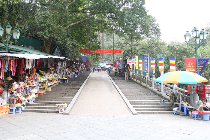 13h chiều, điểm đầu tiên của con đường dẫn lên động Hương Tích rộng thênh thang. Người bán hàng vẫn đon đả chào mời khách vãn cảnh nhưng số lượng người dừng chân mua hàng rất ít.