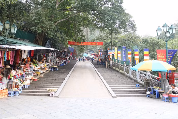 13h chiều, điểm đầu tiên của con đường dẫn lên động Hương Tích rộng thênh thang. Người bán hàng vẫn đon đả chào mời khách vãn cảnh nhưng số lượng người dừng chân mua hàng rất ít.