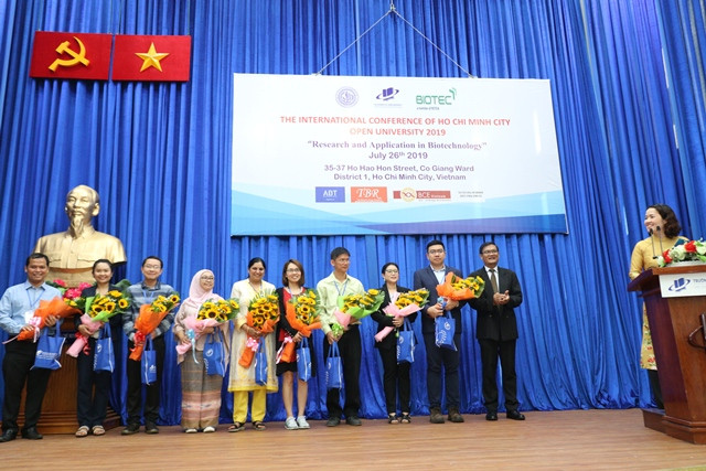 PGS.TS Nguyễn Minh Hà - Hiệu trưởng Trường ĐH Mở TPHCM tặng hoa cho các học giả, nhà nghiên cứu trong và ngoài nước