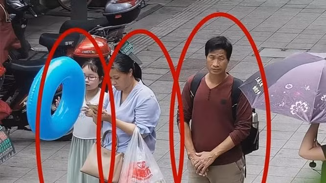 Bức ảnh trích xuất từ camera an ninh cho thấy cô bé Zhang Zixin bị 2 người lớn dẫn đi (Ảnh: Getty).