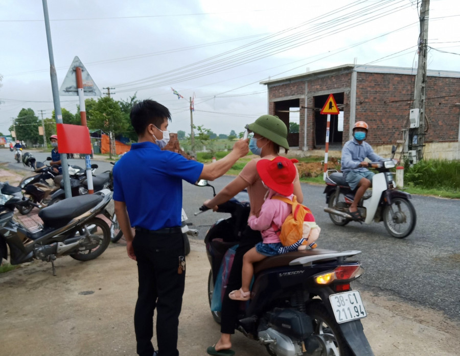 Cán bộ Trạm Y tế trực tiếp đo thân nhiệt cho phụ huynh, học sinh trước khi vào trường. Cán bộ Trạm Y tế trực tiếp đo thân nhiệt cho phụ huynh, học sinh trước khi vào trường.