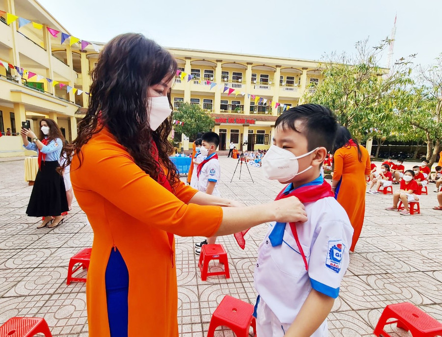 Cô Trịnh Thị Ánh Tuyết - Hiệu trưởng Trường Tiểu học Bắc Hà quàng khăn đỏ cho học sinh được kết nạp Đội viên, Đội TNTP Hồ Chí Minh.