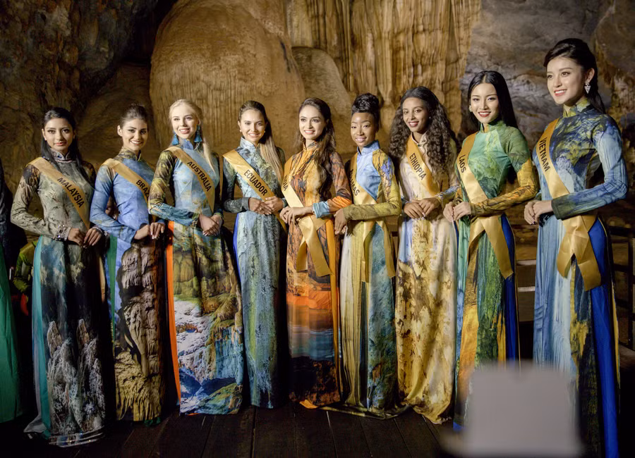Các thí sinh Miss Grand International 2017 chụp ảnh cùng bộ sưu tập áo dài có in hình của Động Thiên Đường do nhà thiết kế Nhật Dũng thiết kế.