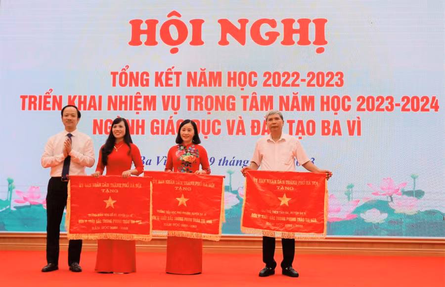 Phó chủ tịch UBND huyện Ba Vì Nguyễn Đức Anh (bìa trái) trao Cờ thi đua xuất sắc của UBND TP Hà Nội cho 3 đơn vị: Mầm non Cổ Đô, Tiểu học Phú Phương, THCS Tản Đà.