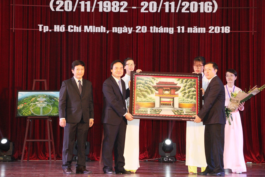 Bộ trưởng Bộ GD&ĐT Phùng Xuân Nhạ (trái) tặng quà chúc mừng cho Ban Giám đốc Đại học Quốc gia TPHCM