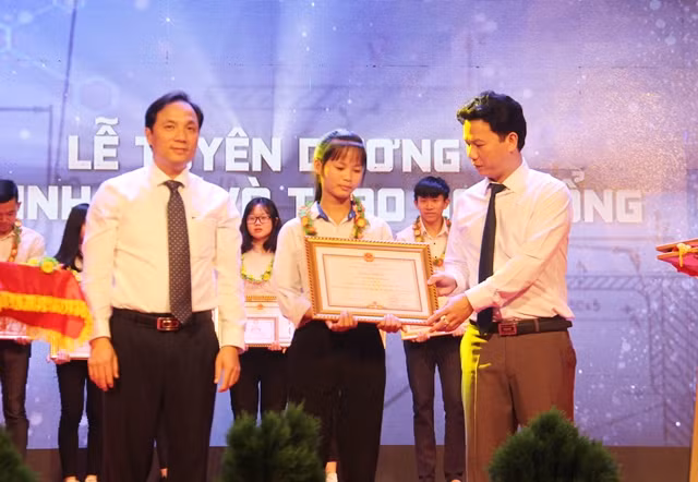 Chủ tịch UBND tỉnh Hà Tĩnh Đặng Quốc Khánh (bên phải) và ông Hoàng Trung Dũng, Phó Bí thư Tỉnh ủy (bên trái) trao tặng bằng khen cho các học sinh đạt giải Nhất.