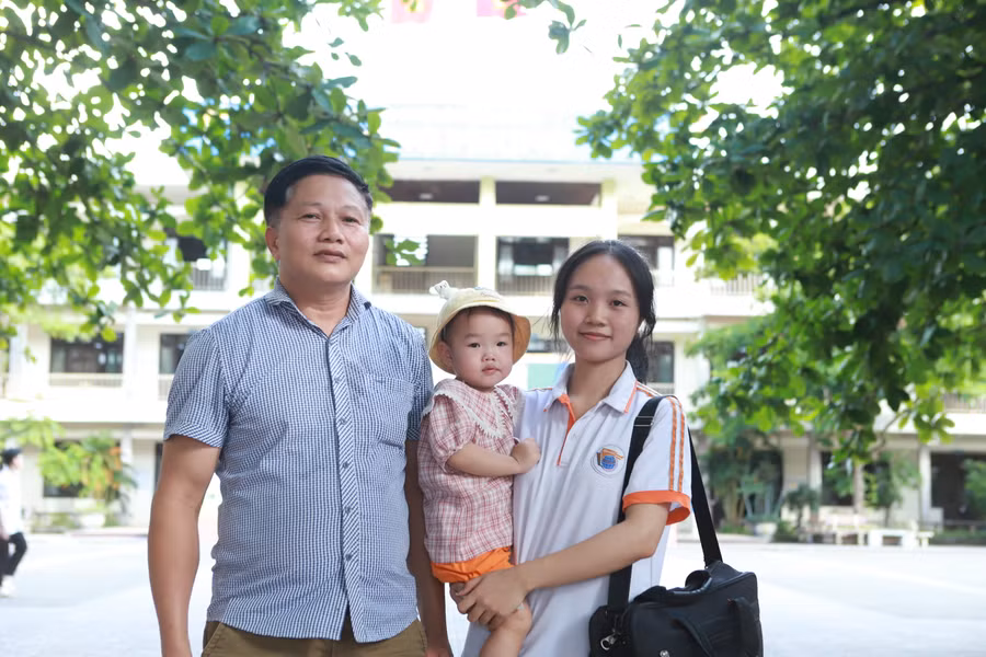 Ông Trần Văn Hùng cùng cháu ngoại đến tận trường thi để đón con gái sau buổi thi Toán chiều 27/6.