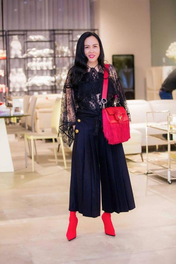 Áo ren đen xuyên thấu tay cánh dơi khiến thân hình cô kém thon gọn. Dù đã lên đồ công thức ton - sur - ton nhưng chiếc túi tua rua màu đỏ càng làm tăng độ sến cho set đồ.