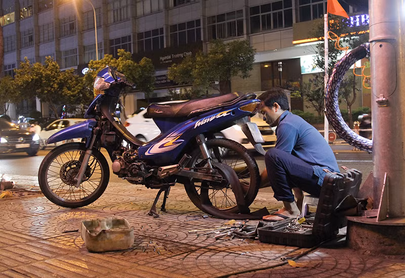 Đều đặn hàng ngày, sau khi kết thúc ca trực bảo vệ, anh Hiếu lại trở về với công việc vá xe đêm vất vả