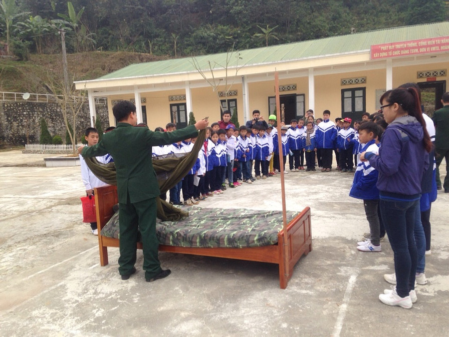Bộ đội biên phòng hướng dẫn học sinh gấp chăn màn
