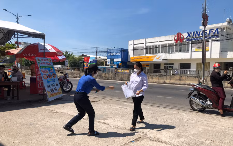 Tình nguyện viên tặng vật dụng cần thiết cho thí sinh.