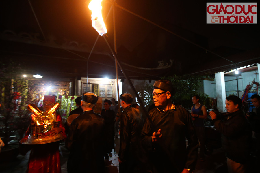 Những người cao tuổi trong làng bắt đầu đốt đuốc mồi và bê vàng mã ra ngoài sân đình