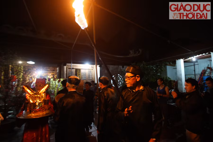 Những người cao tuổi trong làng bắt đầu đốt đuốc mồi và bê vàng mã ra ngoài sân đình