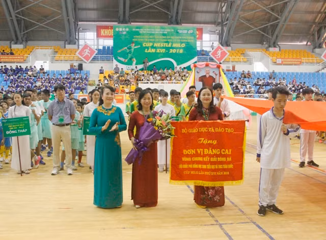 Thứ trưởng Nguyễn Thị Nghĩa tặng cờ và hoa cho lãnh đạo sở GD&ĐT tỉnh Quảng Trị, đơn vị đăng cai tổ chức vòng chung kết cúp Milo 2018.
