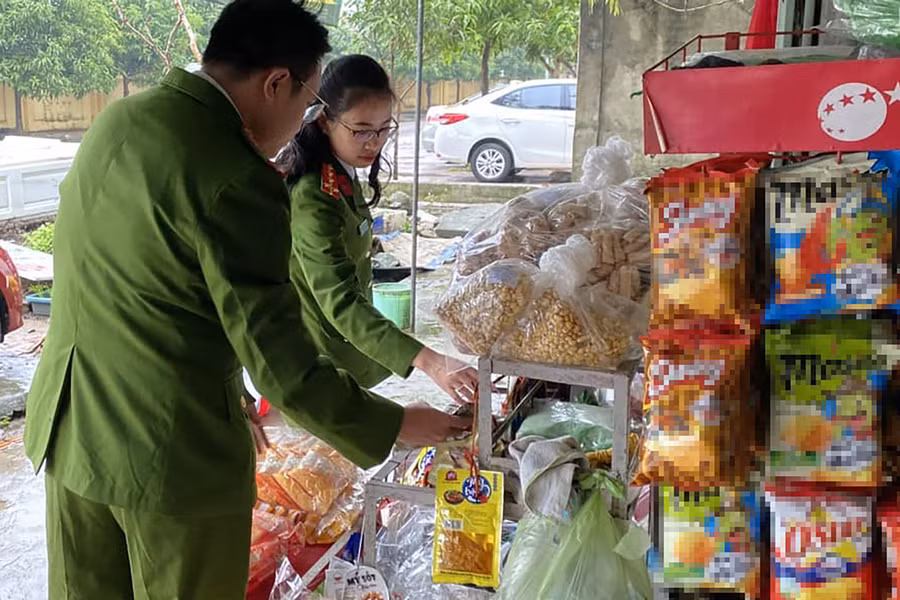 Lực lượng chức năng kiểm tra các ki-ốt kinh doanh bánh, kẹo gần trường học. (Ảnh: Công an TP Vinh)