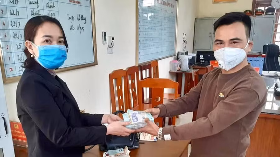 Anh Trọng (bên phải) trao trả lại toàn bộ tài sản nhặt được cho người đánh mất